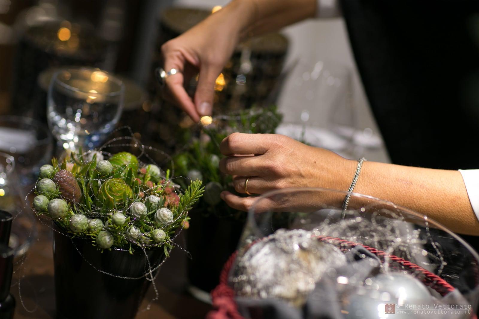 Mani che compongono fiori e foglie per una tavola