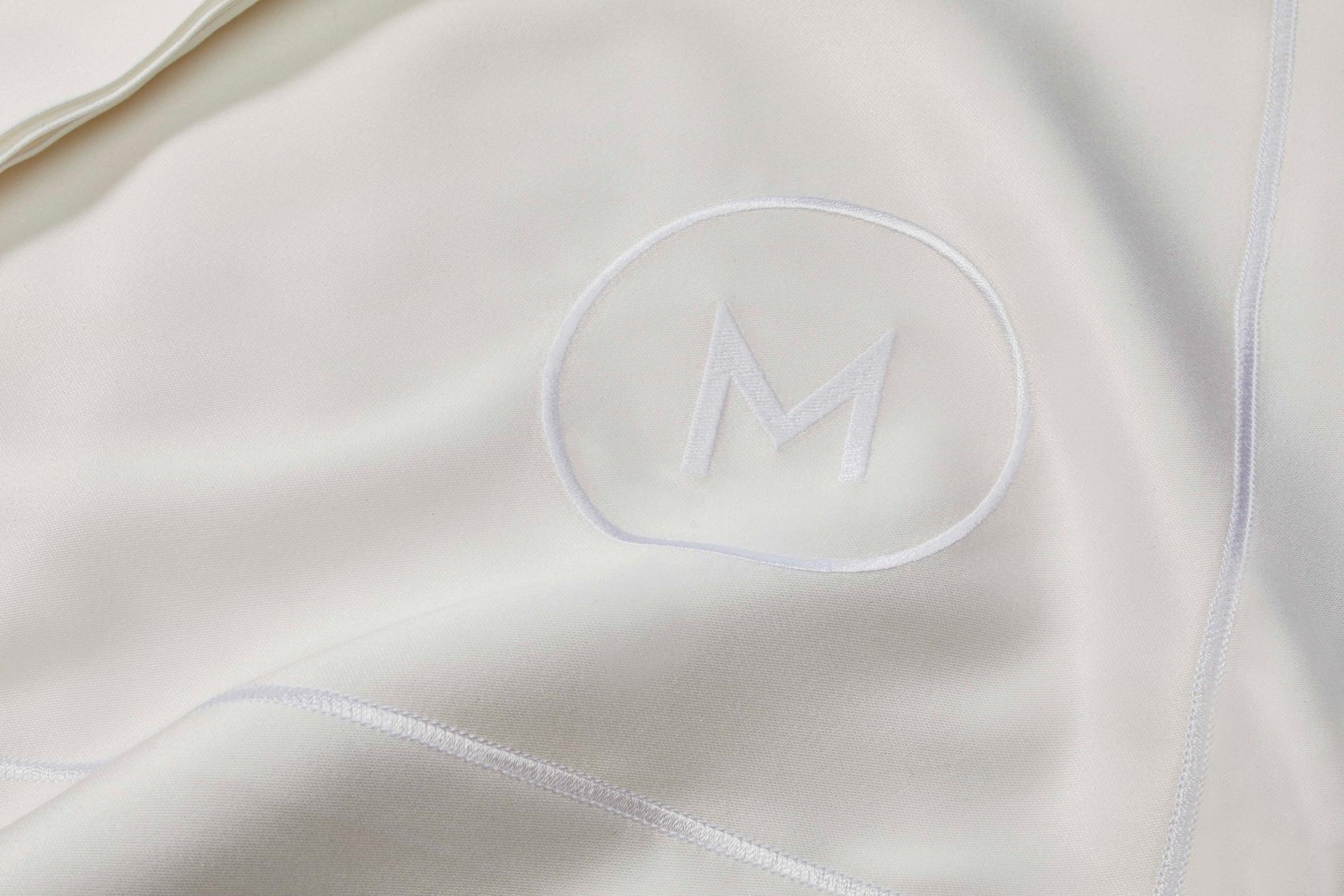 Il monogramma M su un tessuto bianco