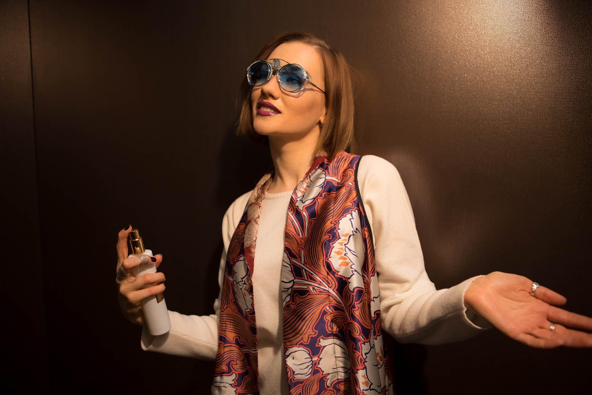 Una donna con un foulard aperto sulle spalle e gli occhiali da sole