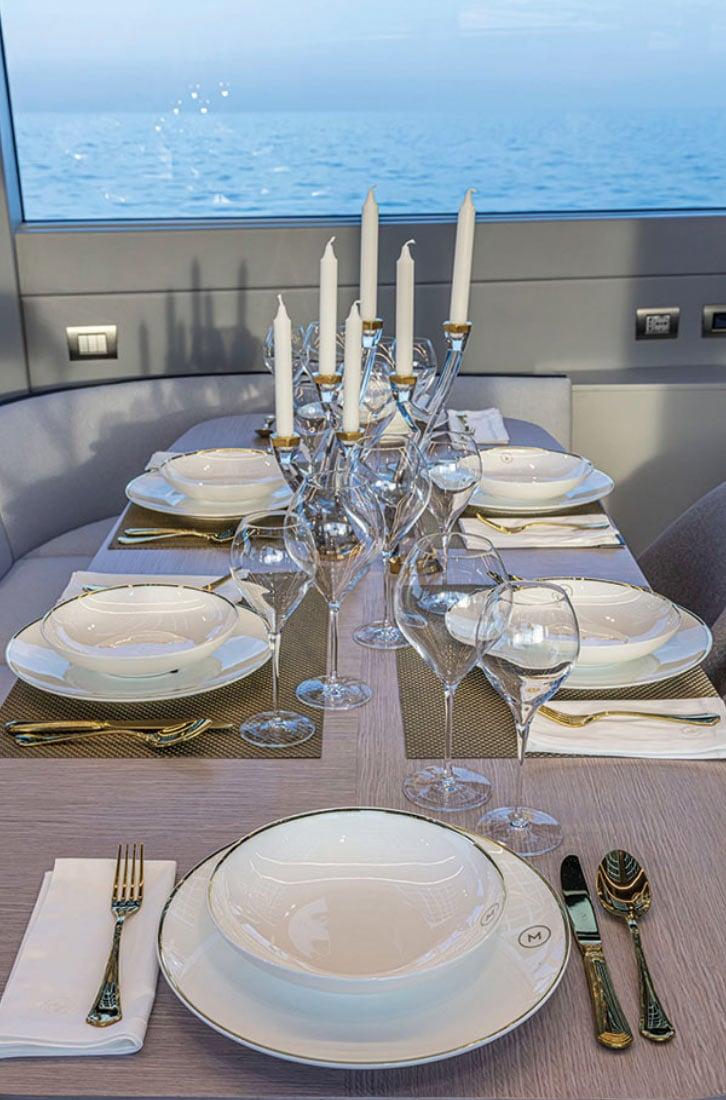 Una cena a bordo, con candelabri e piatti bianchi